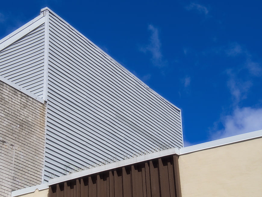 Modern industrial building facade with corrugated metal and blue sky