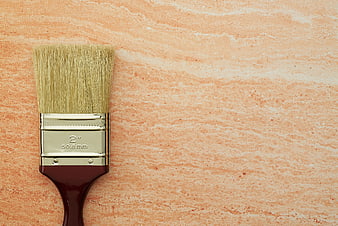 Paintbrush on textured peach background with copyspace