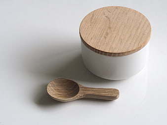 Minimalist white ceramic jar with wooden lid and spoon