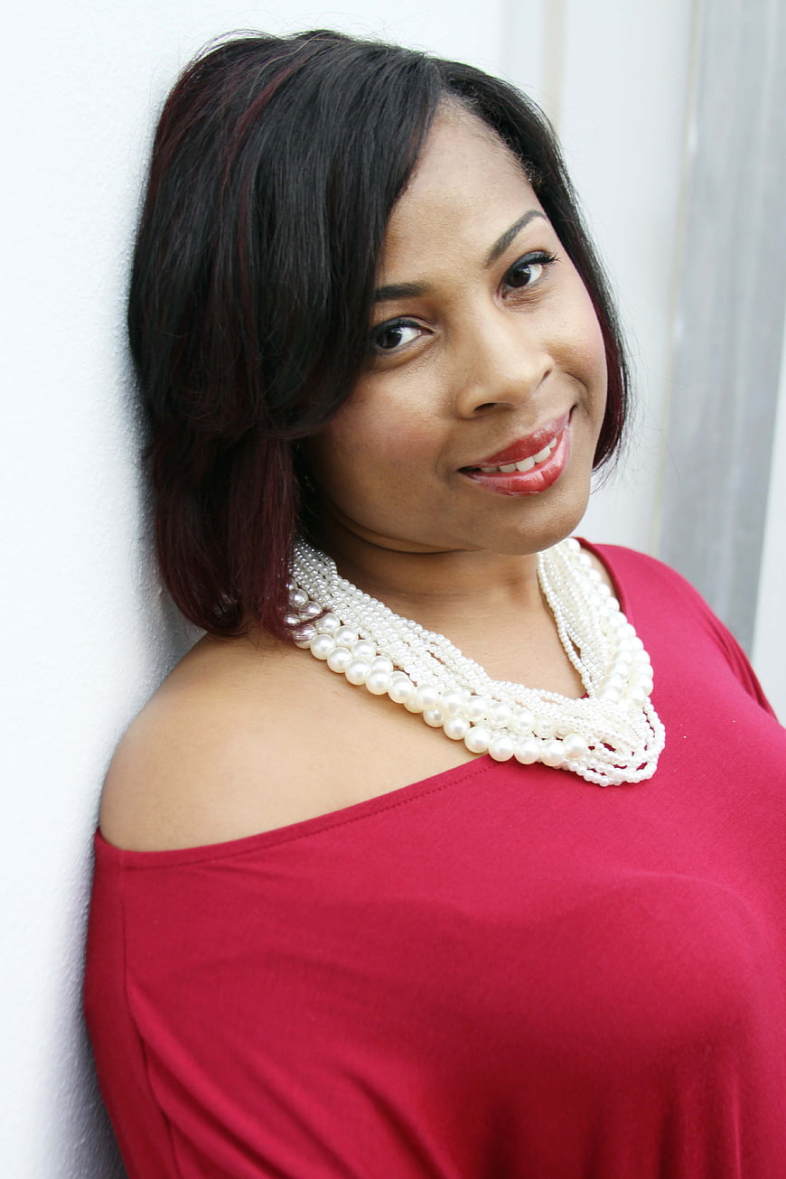 Portrait of Smiling Woman in Red Top with Pearl Necklace