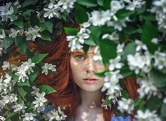 Redhead Woman with Freckles Surrounded by White Jasmine Flowers