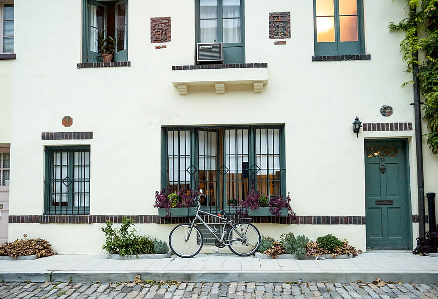 Vintage bicycle parked in front of a cream-colored house facade