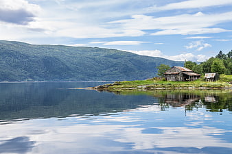 Serene Lake Landscape with Rustic Cabin and Mountain Reflection