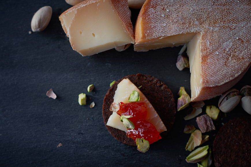Artisanal Cheese Platter with Pistachios and Jam on Slate