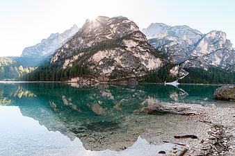Serene Alpine Lake with Mountain Reflections and Sunburst