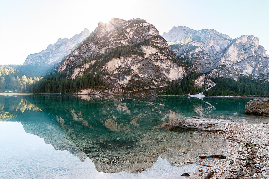 Serene Alpine Lake with Mountain Reflections and Sunburst