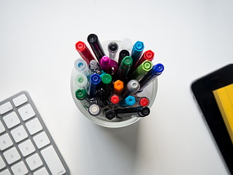 Top View of Colorful Markers in a Cup on a White Desk