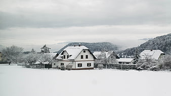 Snowy Village Landscape with Traditional Houses and Mountains