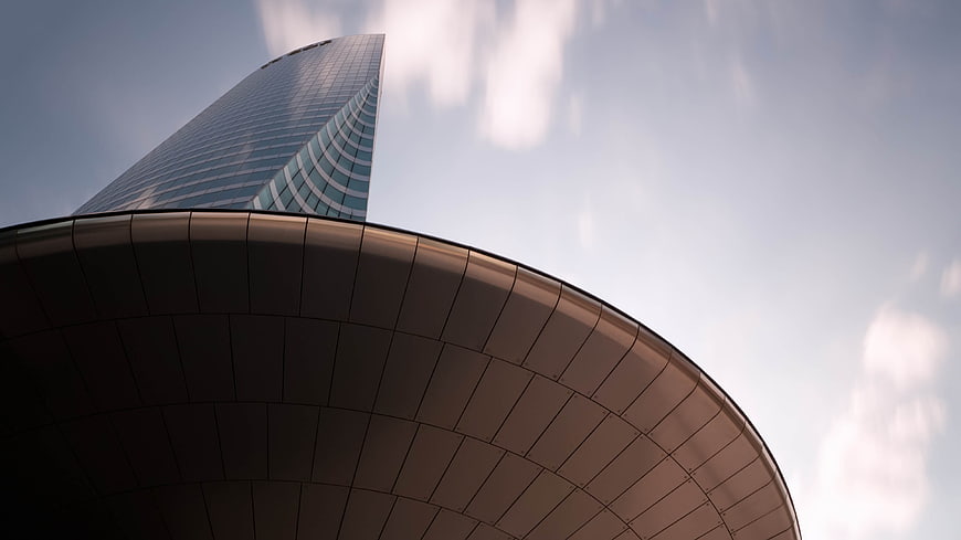 Low angle view of modern glass skyscraper and curved building