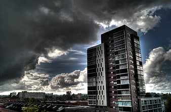 Modern High-Rise Apartment Building Under Dramatic Stormy Sky