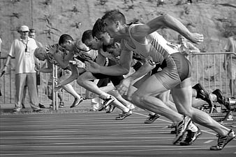 Sprinters exploding from starting blocks on track