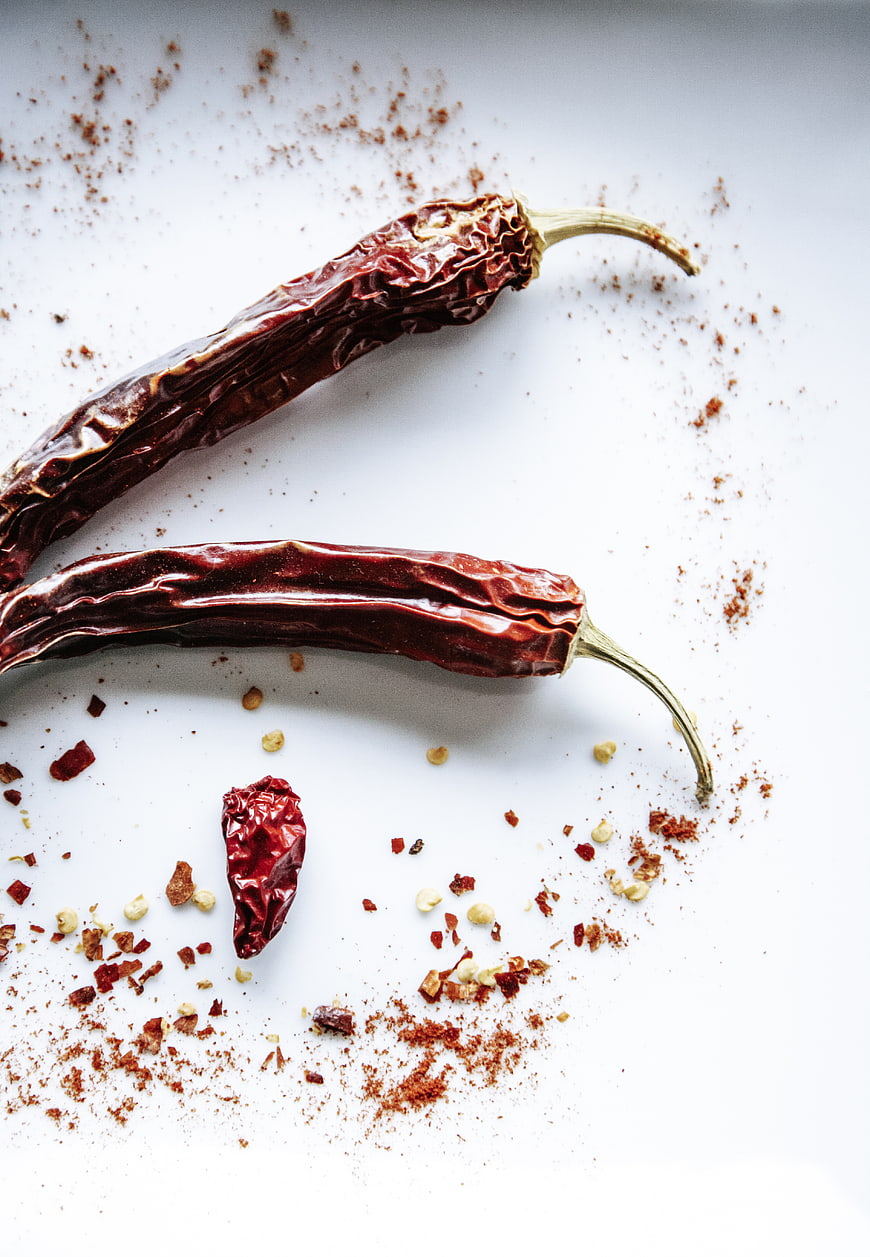 Dried red chili peppers and spices on white background