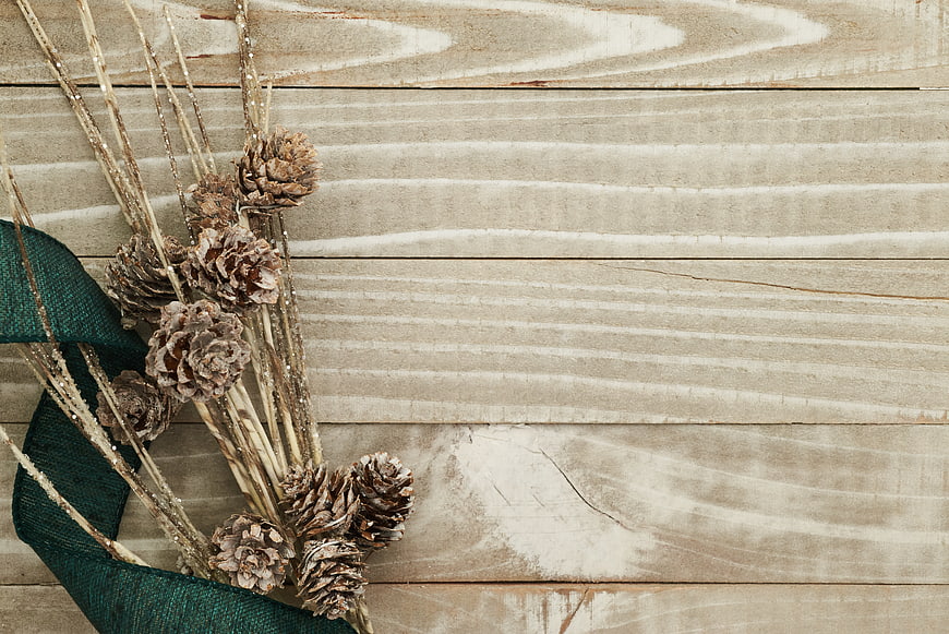 Rustic Christmas Pine Cones and Ribbon on Wooden Background