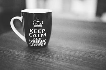 Black and white coffee mug with Keep Calm text on wooden table