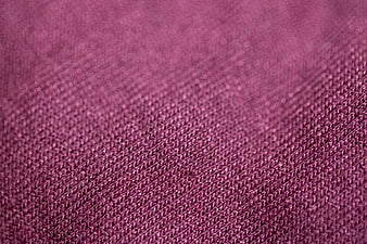 Close-up of textured maroon fabric with diagonal weave pattern