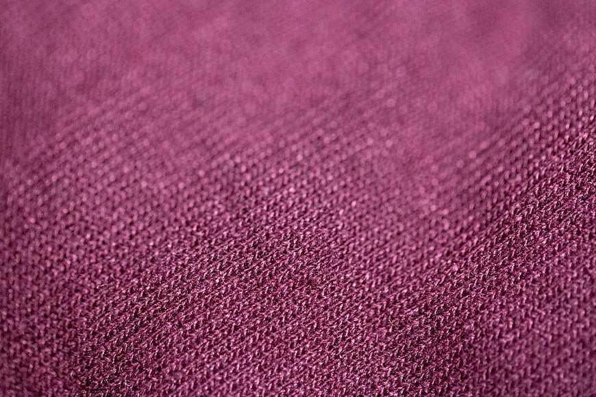 Close-up of textured maroon fabric with diagonal weave pattern