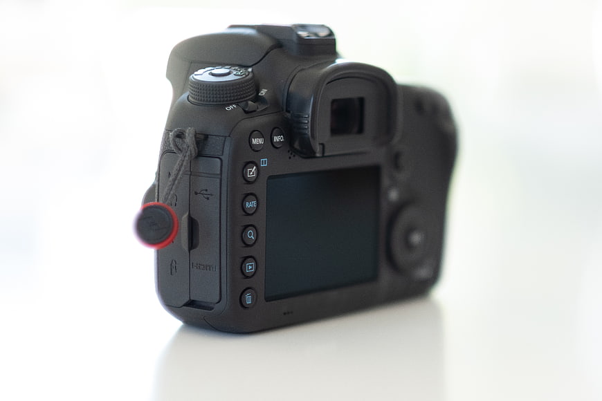 Back view of black DSLR camera on white background