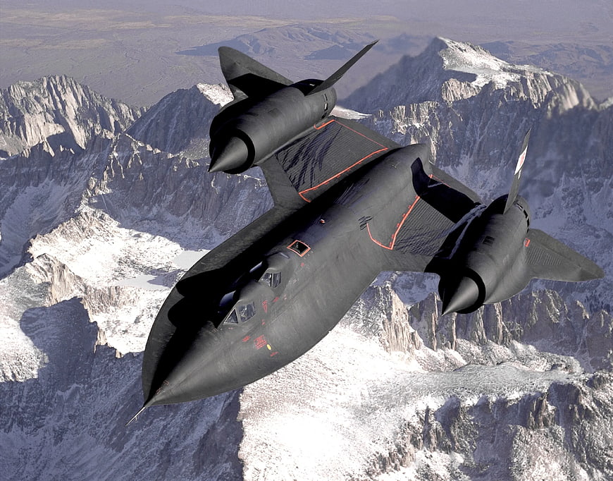 Black Stealth Bomber Flying Over Snowy Mountains