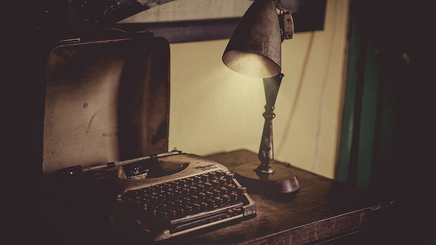 Vintage Typewriter and Lamp on Wooden Desk