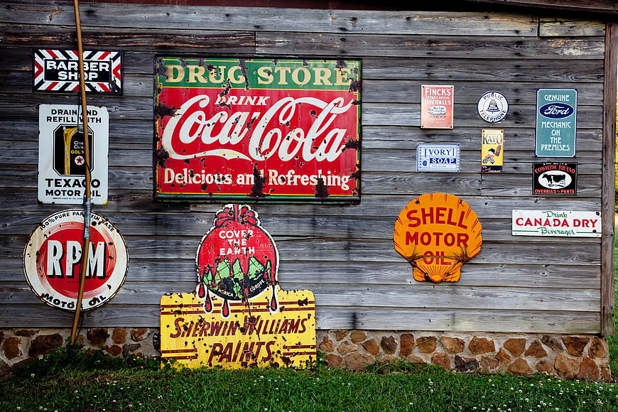 Vintage Tin Signs on Weathered Wooden Barn Wall