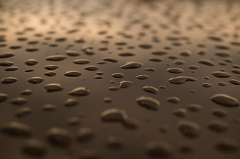 Close-up of water droplets on a reflective surface with shallow depth of field