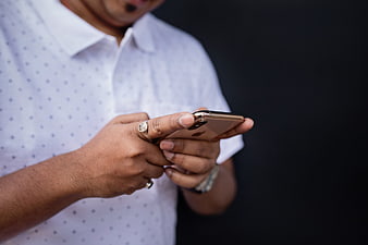 Man in White Shirt Using Smartphone