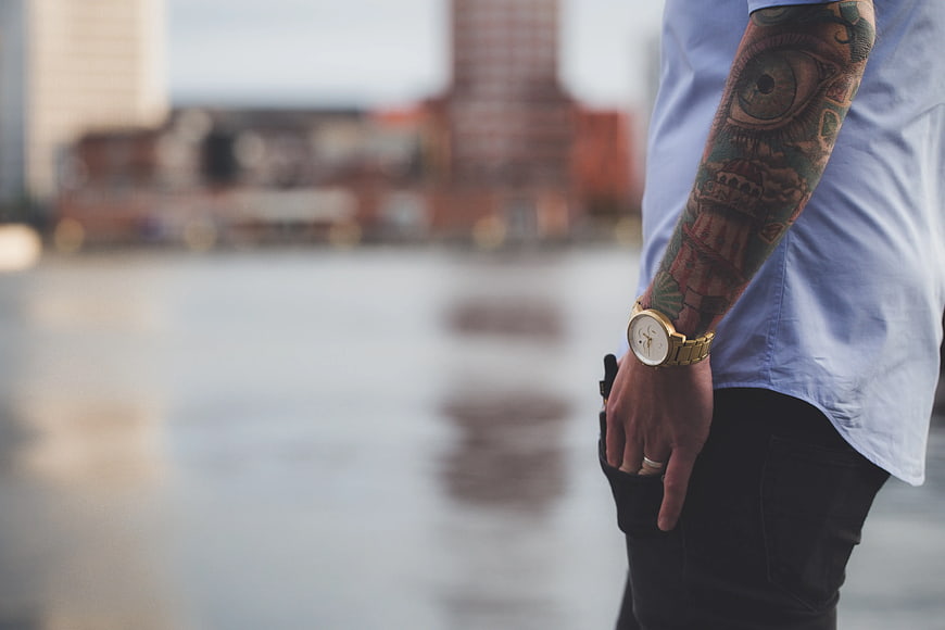 Man with Tattooed Arm and Gold Watch by Water