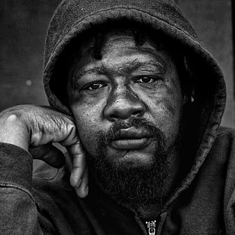 Black and white portrait of a man in a hoodie
