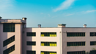 Modern Pink Building with Yellow Windows and Blue Sky