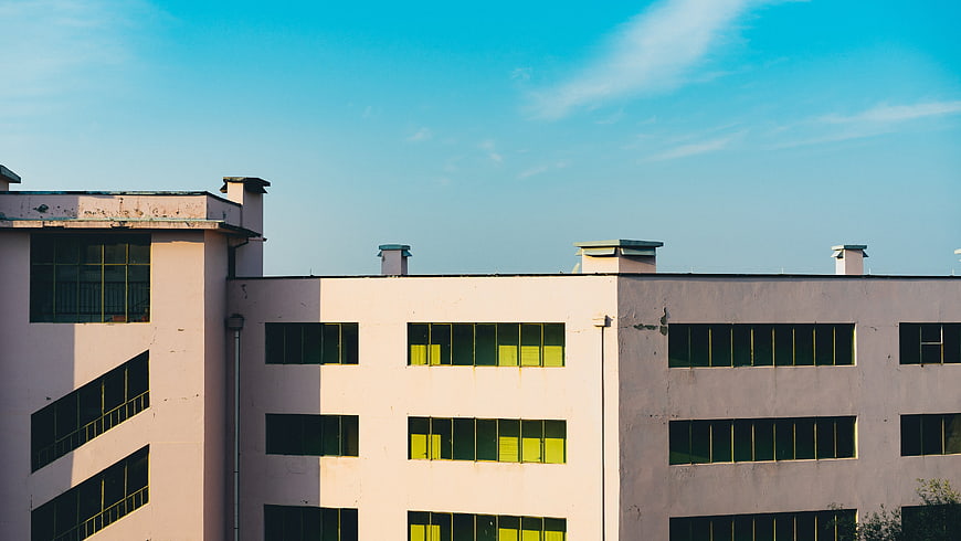 Modern Pink Building with Yellow Windows and Blue Sky