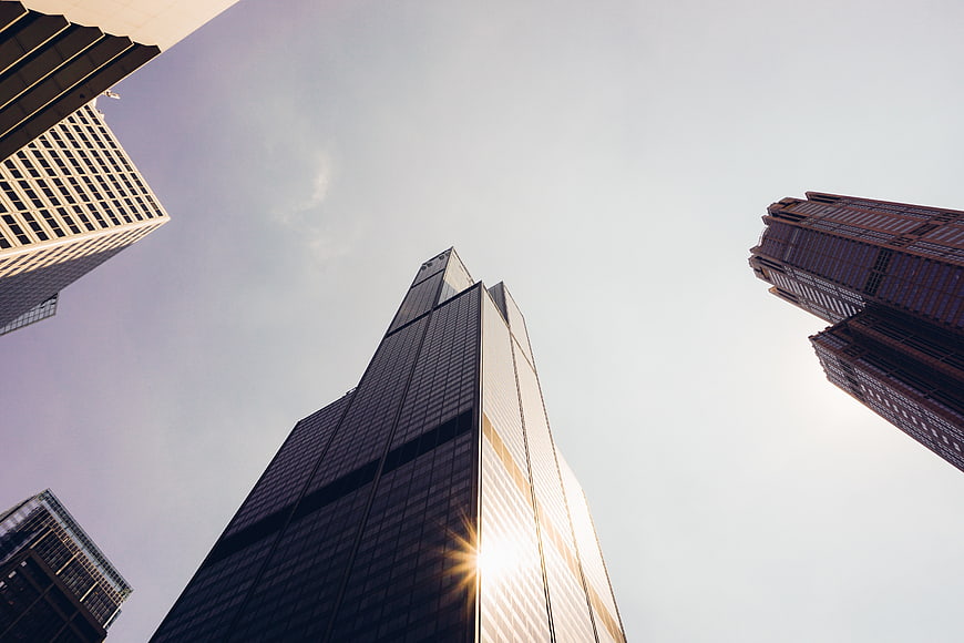 Low angle view of modern skyscrapers with sun flare