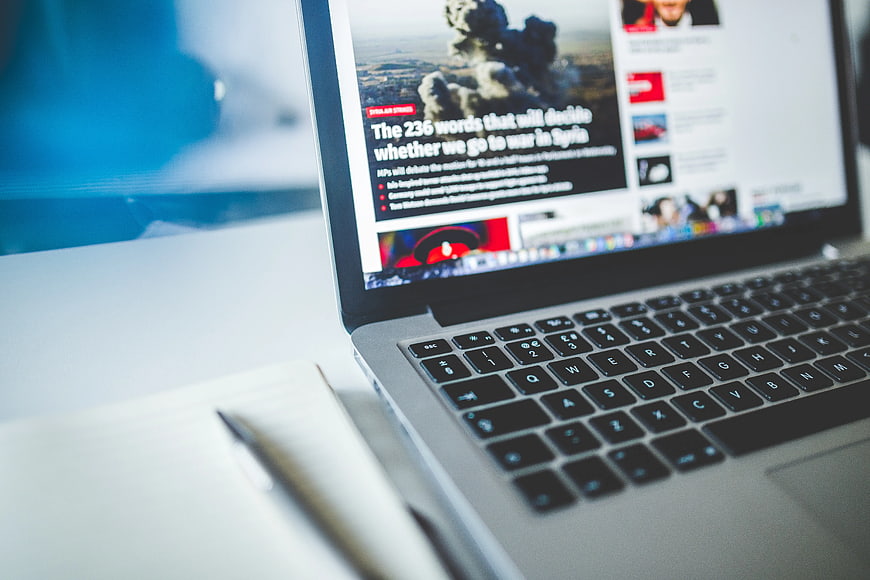 Laptop displaying news article about war in Syria