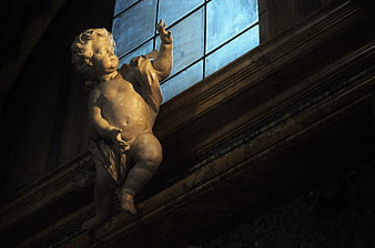 Marble Cupid Statue Reaching for Light in Dark Interior