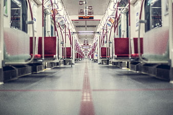 Empty subway car interior with red seats and leading lines