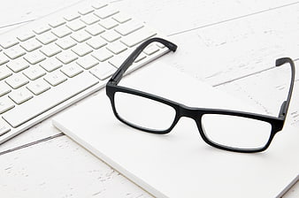Black Glasses on White Notebook and Keyboard