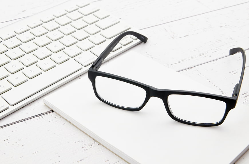 Black Glasses on White Notebook and Keyboard