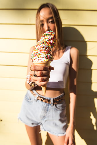 Woman holding ice cream cone with sprinkles