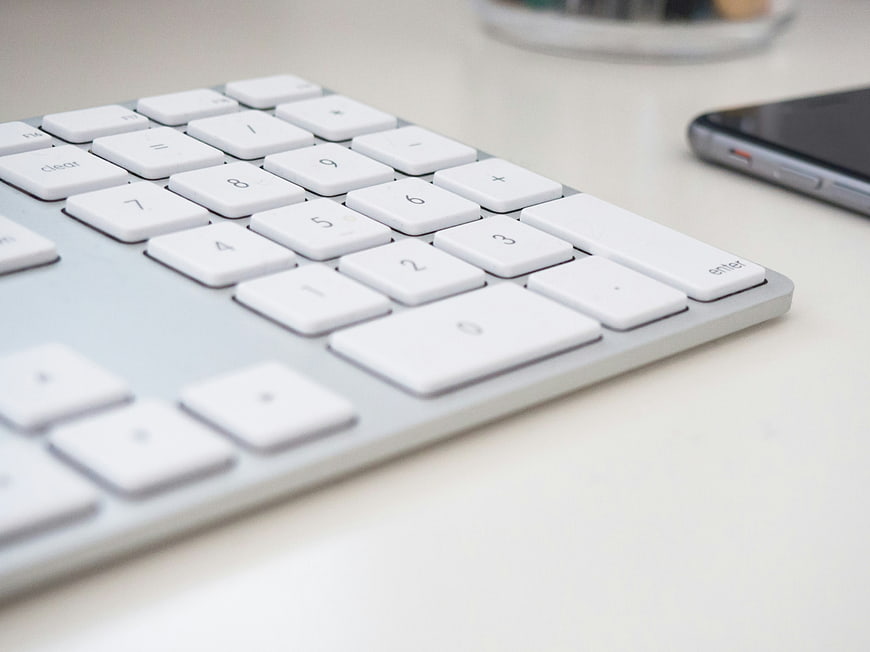 Close-up of white calculator keyboard on desk