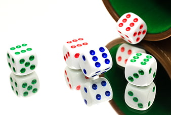 Colorful Dice Spilling from a Cup on White Background