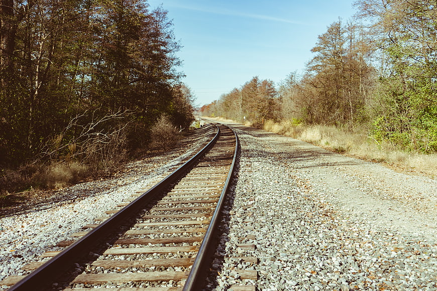 Curved Railway Tracks Through Autumn Forest Landscape