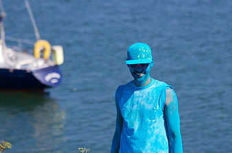 Man Covered in Blue Powder Paint by the Sea