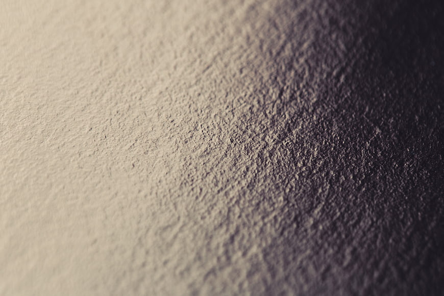 Close-up of textured plaster wall with dramatic lighting