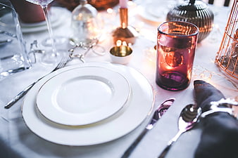 Elegant Holiday Table Setting with Amber Candle and White Plates