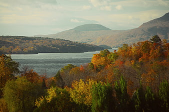 Scenic autumn landscape with lake, mountains, and colorful foliage