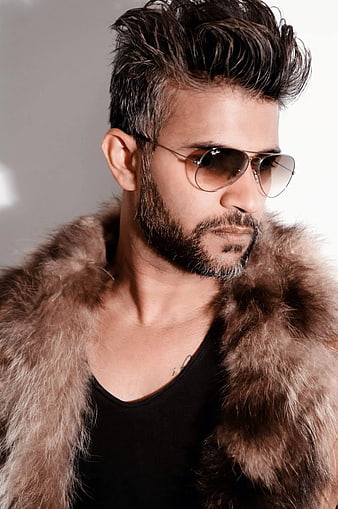Stylish man wearing aviator sunglasses and fur coat