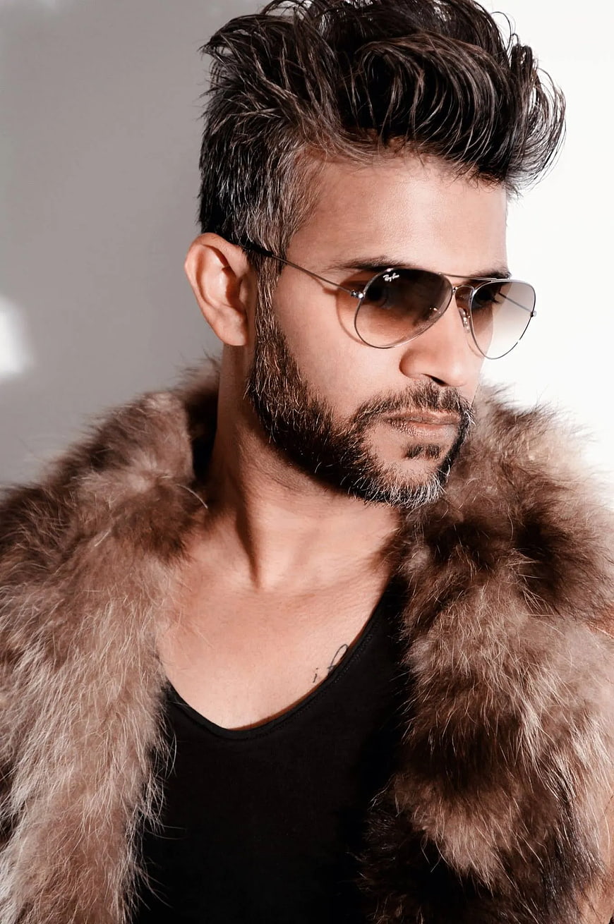 Stylish man wearing aviator sunglasses and fur coat