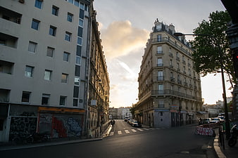 Parisian street corner with classic architecture and graffiti at sunset