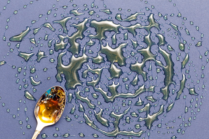 Top View of Honey Spoon and Liquid Splash Pattern
