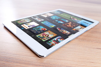 White tablet displaying movie streaming app on wooden desk