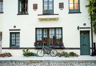 Vintage bicycle parked in front of a cream-colored urban building facade